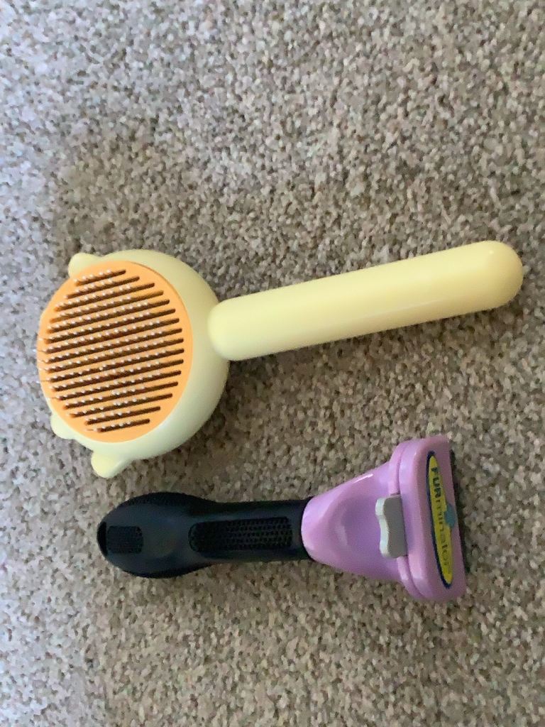 Cat brushes, a furminator and a cat paw brush 