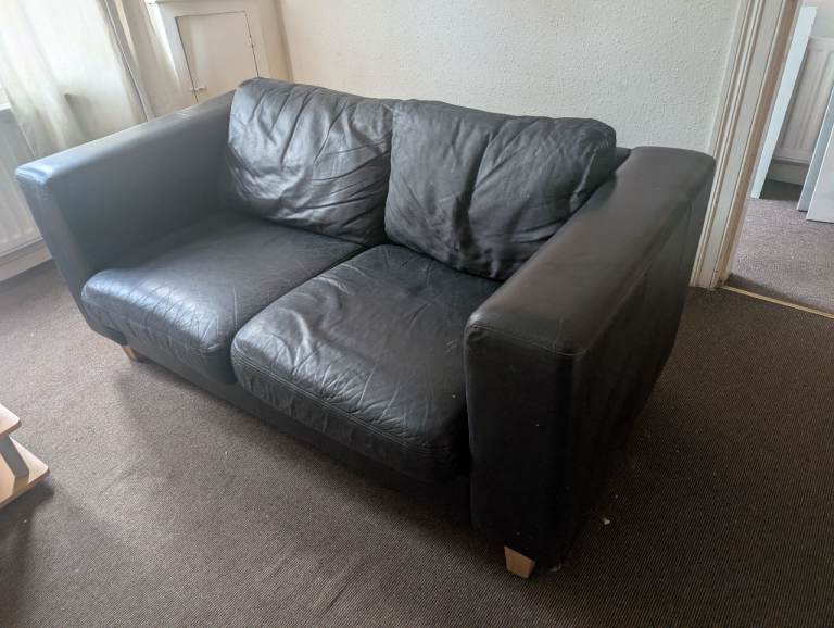 Two seater black leather look sofa