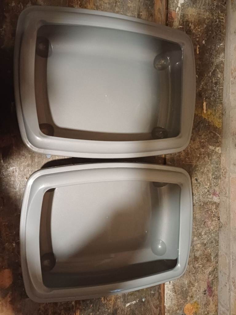 Two plastic medium pet litter trays with rims