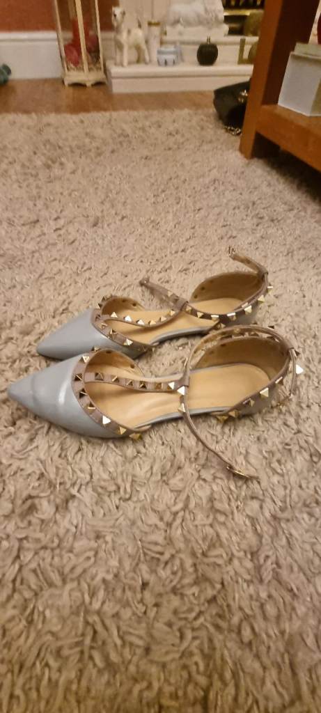 Light blue flat shoes with pink trim and metal stud detail