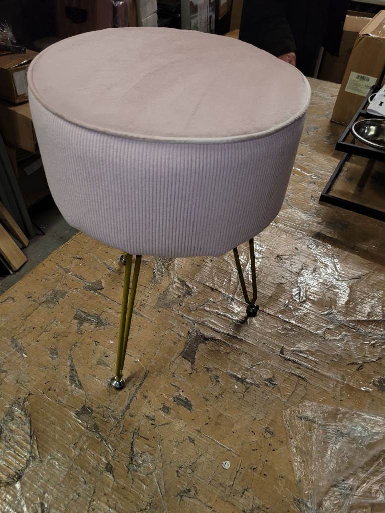 A new pail pink fabric Stool Round With gold legs. 