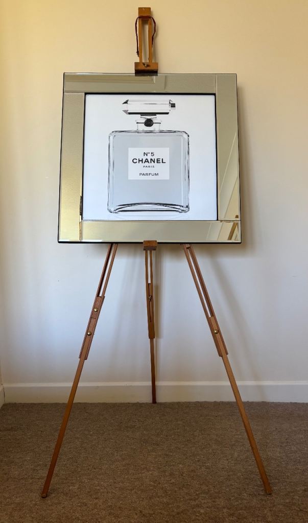 A mirror framed piece of advertising art depicting a classic Chanel N°5 Perfume bottle