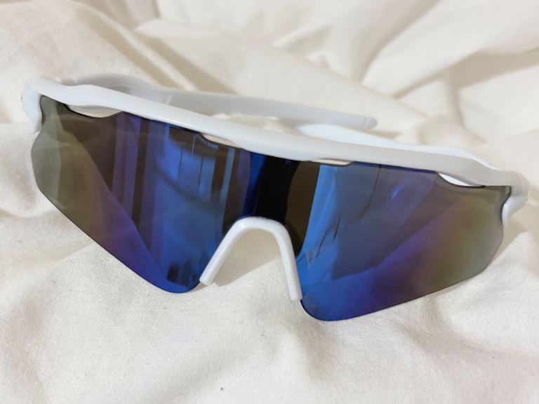 White frame sports sunglasses featuring a mirrored blue tint shield lens.