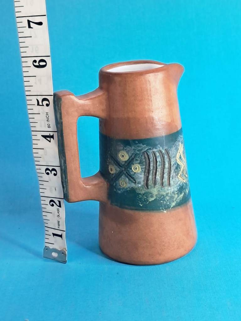 vintage ceramic pitchera rustic terracotta-colored base and a textured.