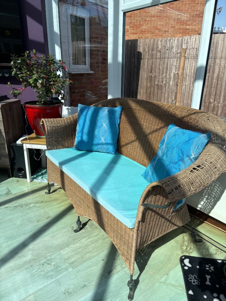 Wrought iron and wicker settee.