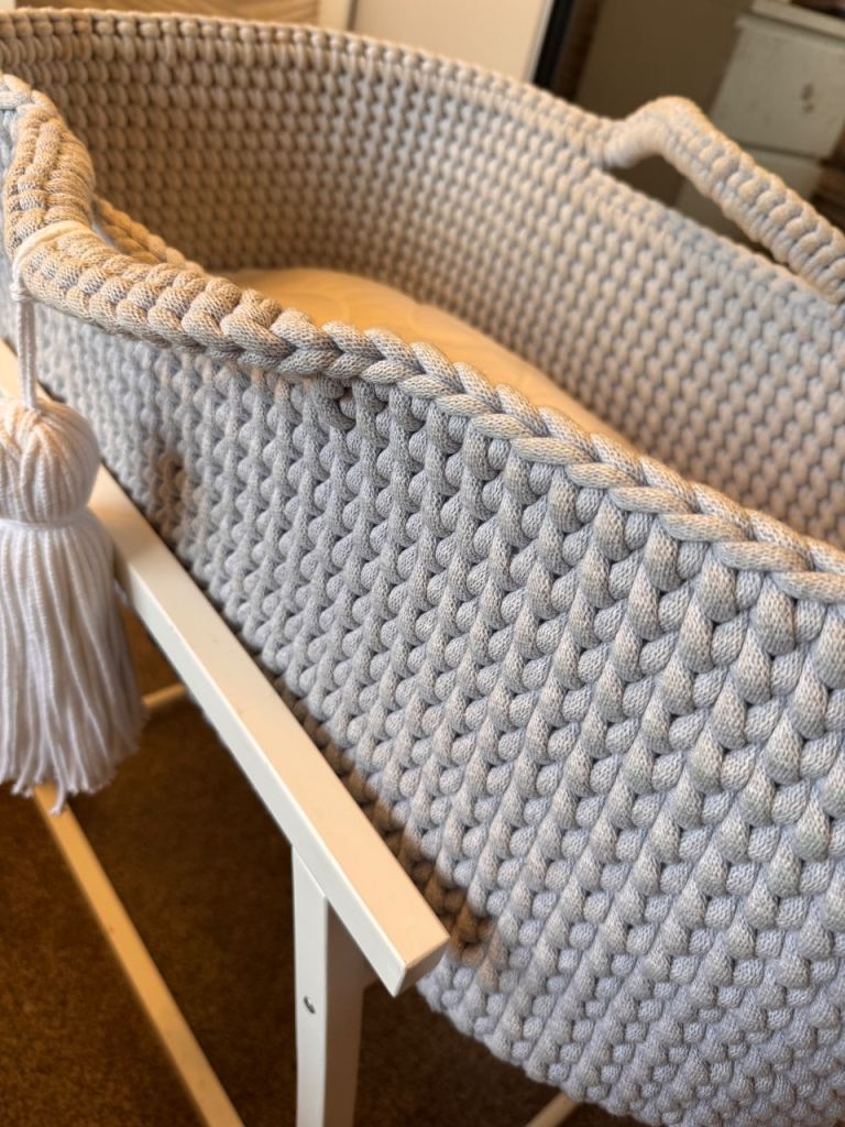 Light grey crochet crib with white wooden stand 