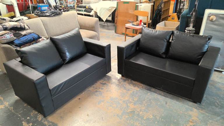 2 small 2 seater sofas finished in black leatherette