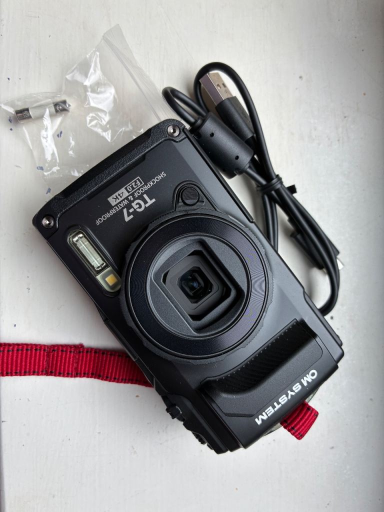OM System TG-7 Camera with SanDisk 128GB Card, protective lens, screen cover and Case – As New