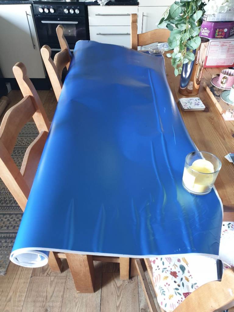 Large roll of vinyl wrap looks metallic blue when open, looking for offers