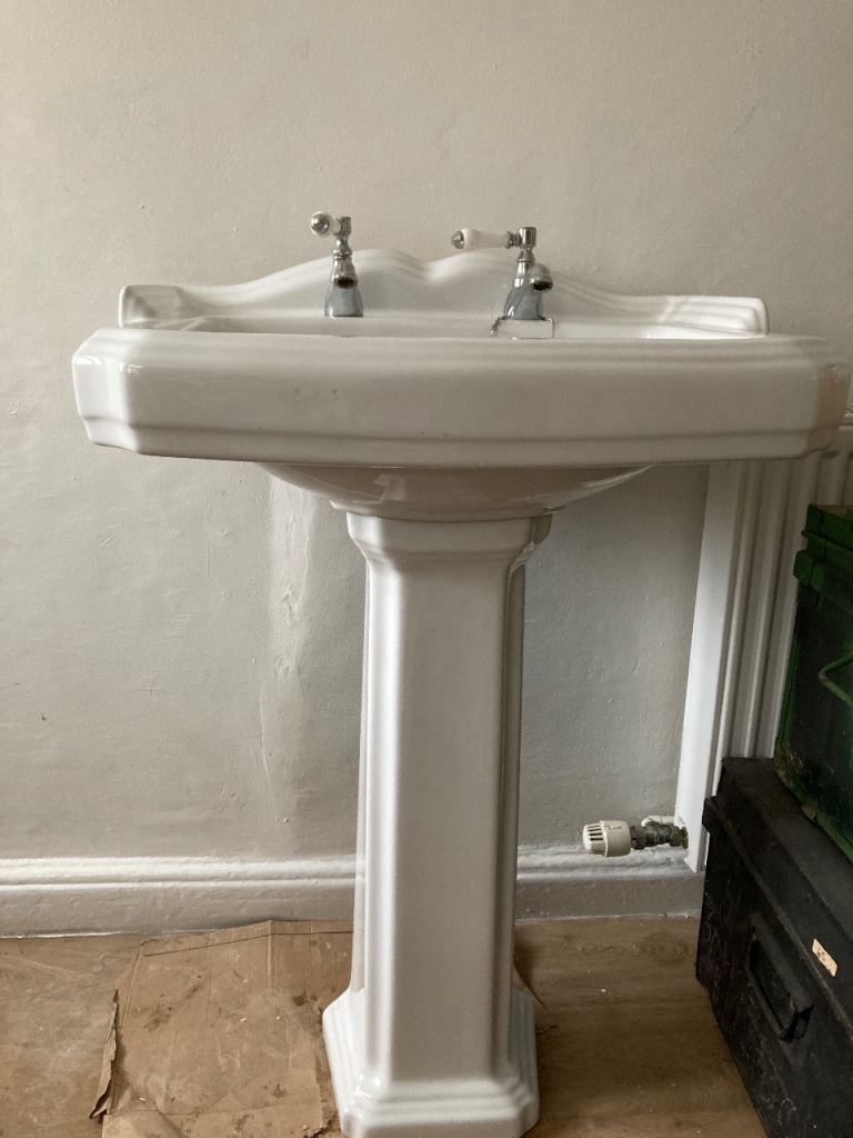 Elegant basin and pedestal with tap fittings and waste pipe and copper.