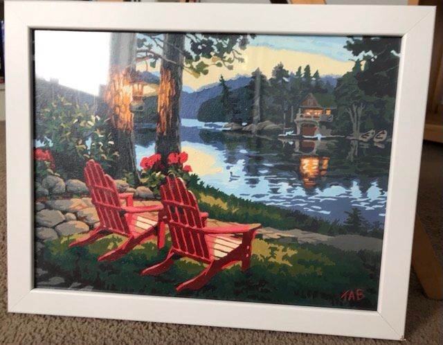 Framed Lake Scene Painting with Red Chairs 