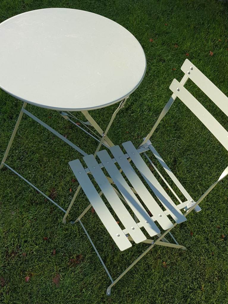 A Folding Metal Bistro Table with 1 Chair.