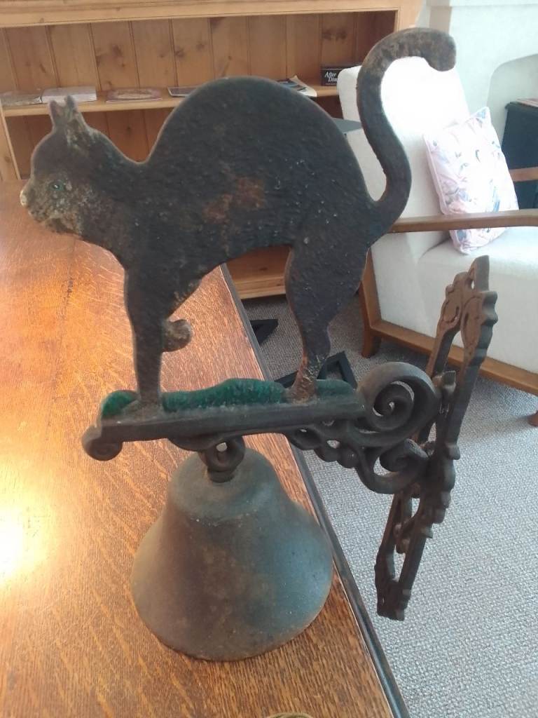 Antique pub bell featuring a cat