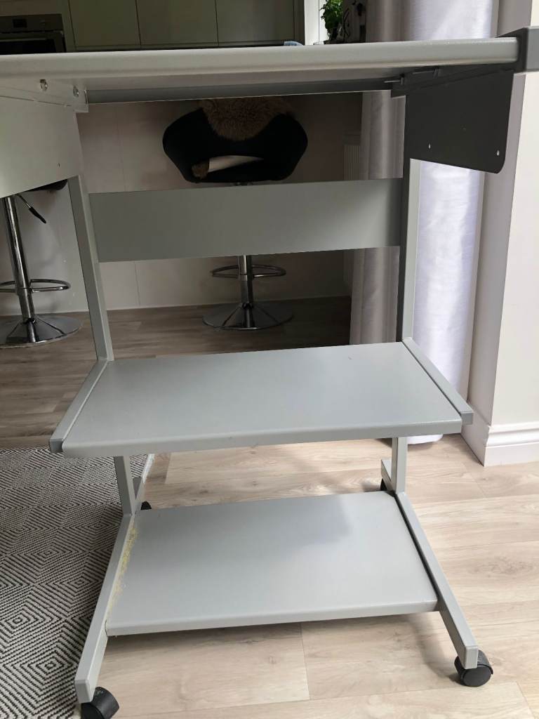 Metal computer stand with three shelfs and castors. 