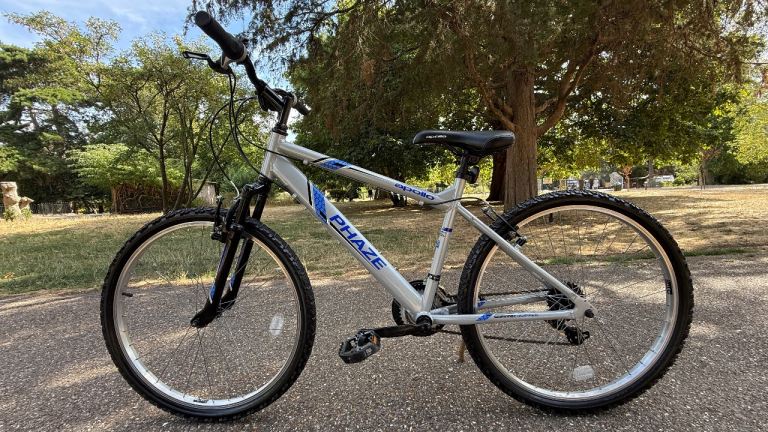 Unisex bike, Apollo Phaze mountain bike featuring a silver frame and blue graphic in good condition