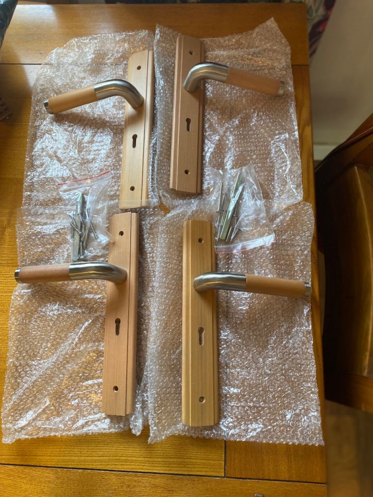 4 unused, light oak and stainless steel door handles with lock openings 