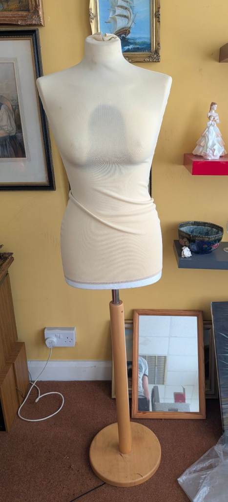 Colored female mannequin torsos on wooden stands .