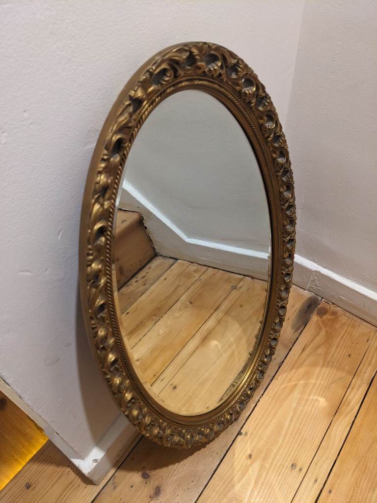 Oval gold-framed mirror