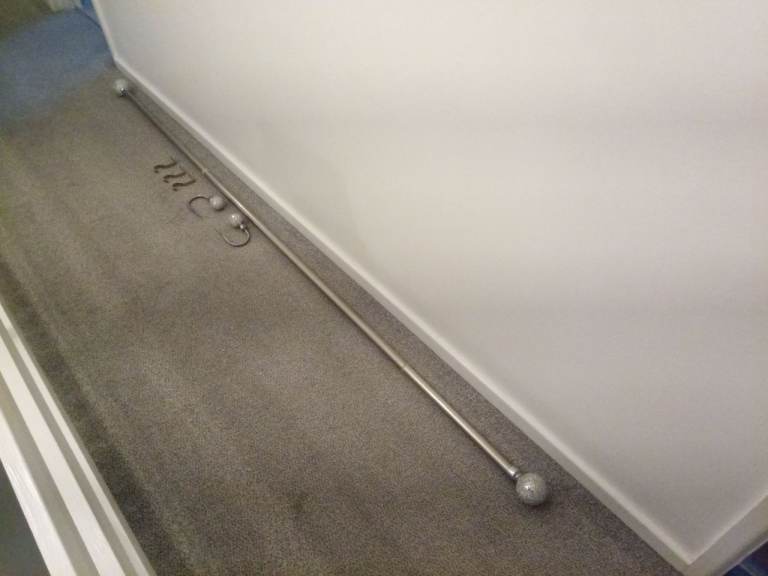 Chrome extendable curtain pole with matching hold backs.