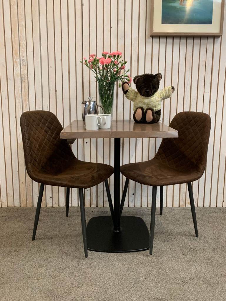 Bistro Dining Table with two Chairs, featuring Square Brown Faux-Suede Seats .