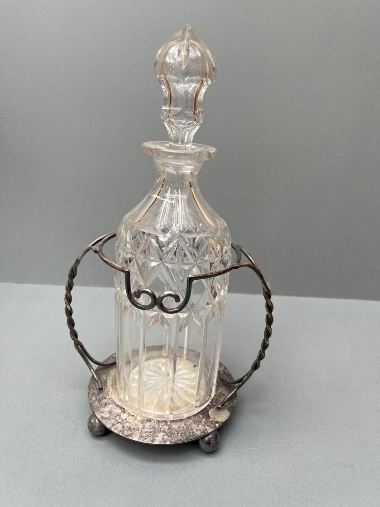 Crystal glass whisky decanter in silver ornate holder 