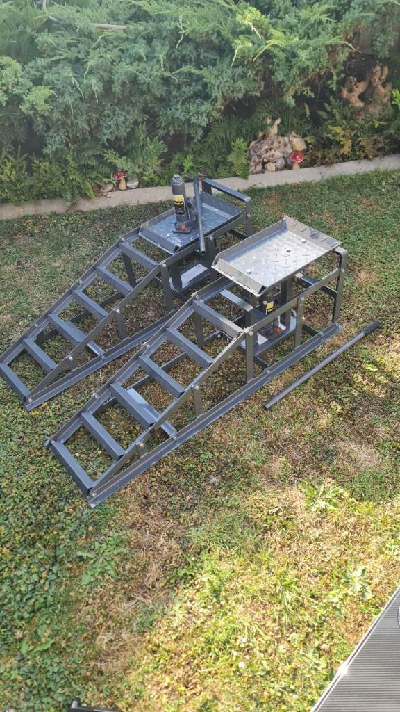Large car ramps with hydraulic jacks.