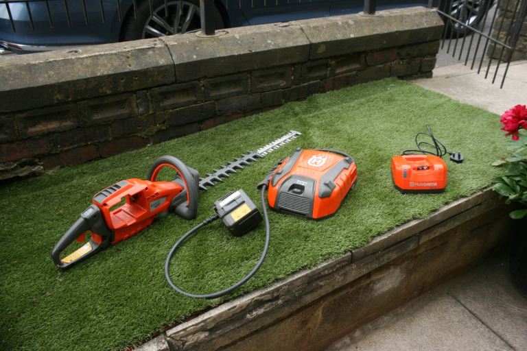 Husqvarna 520iHD60 battery hedge trimmer, with backpack battery, adapter cable and charger.
