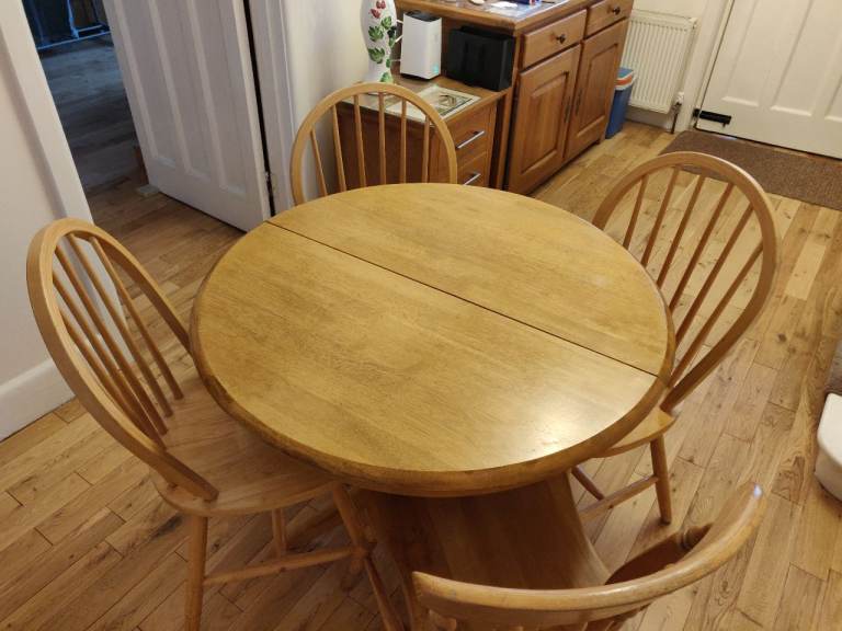 Solid oak extendable round dining table with four chairs