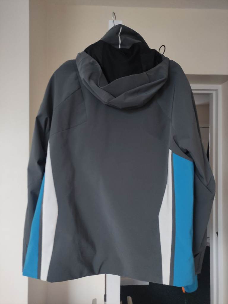 A nearly new male KJUS ski jacket, dark grey, size 48/S, a detachable hood , ski features