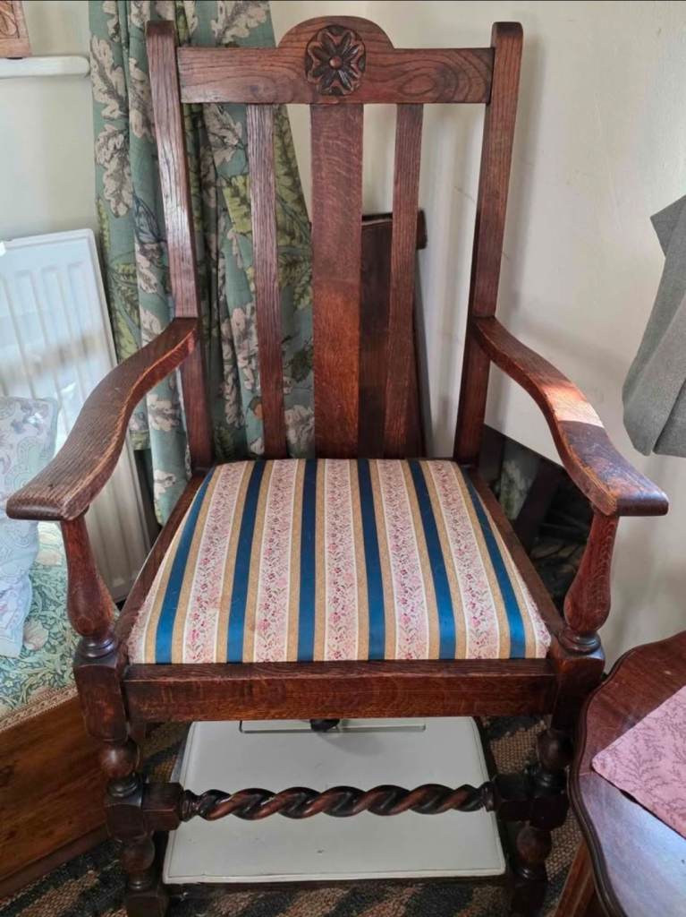 Antique Arts and Crafts style oak armchair with a carved back and barley twist legs