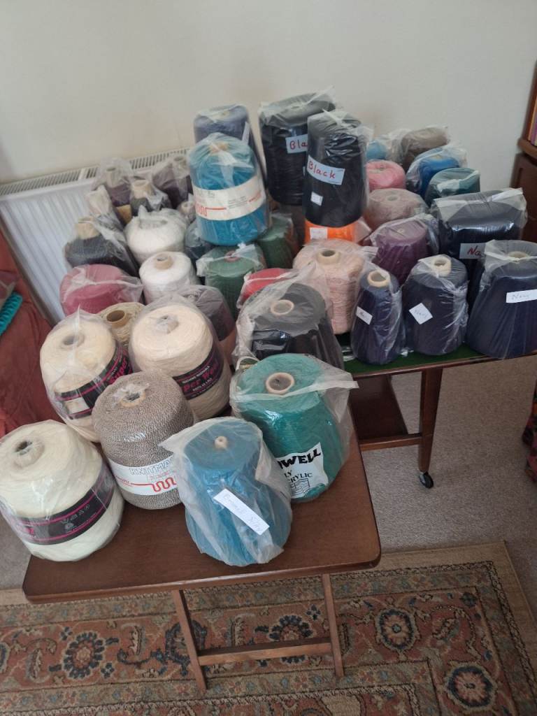 Large selection of cones of knitting yarn for machine