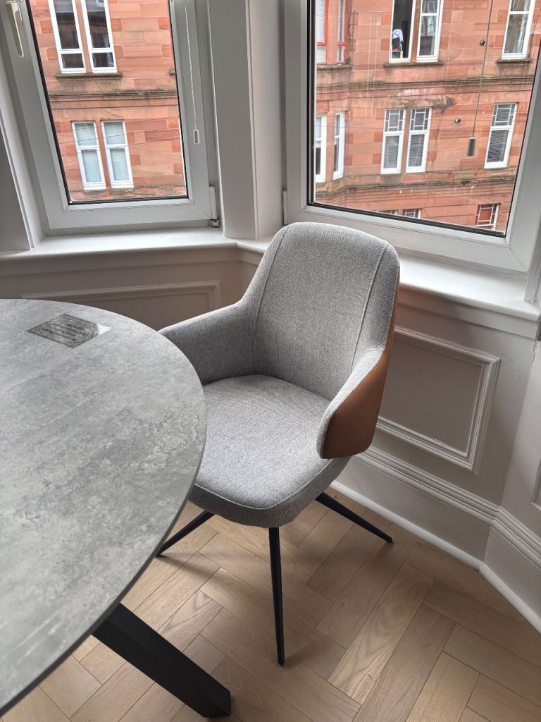 2 grey swivel dining chairs with tan faux leather backs