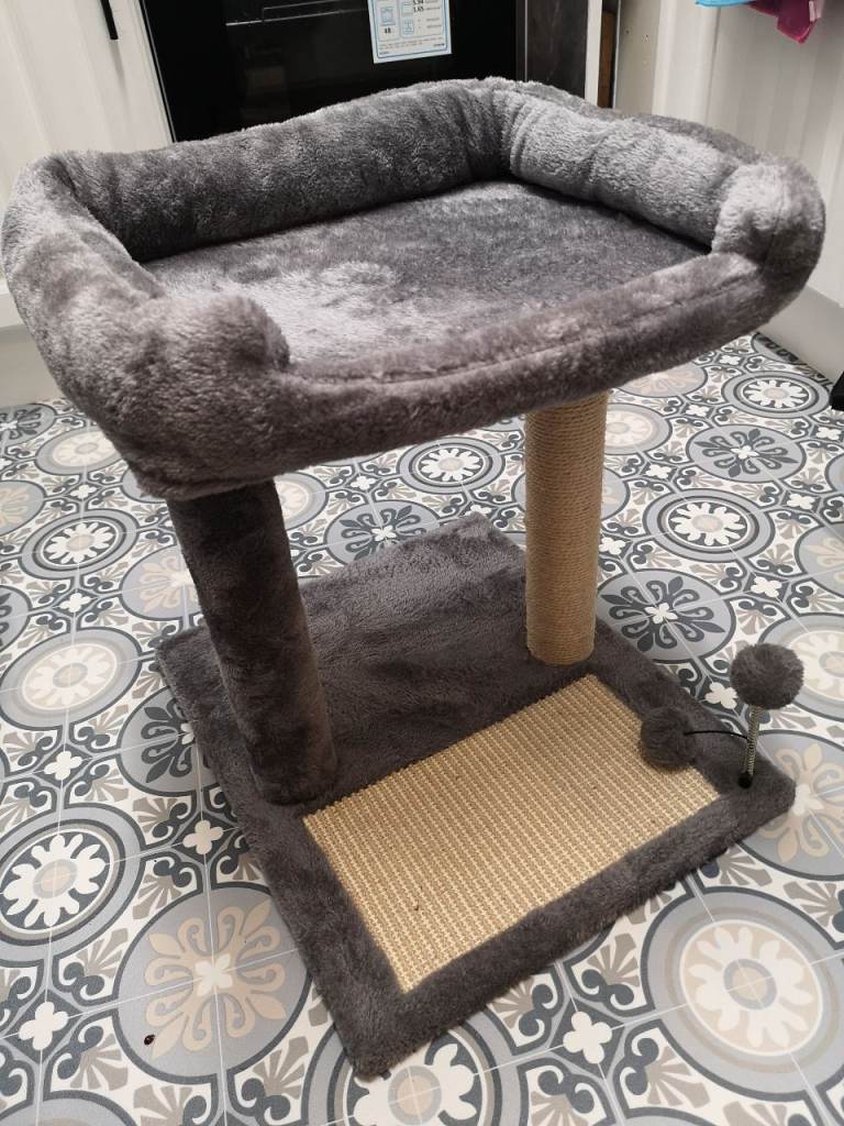 A cat scratching post with raised bed / perch