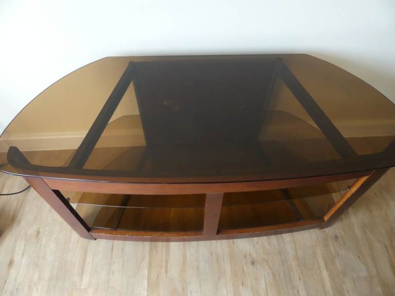 Used mahogany TV stand made of wood and glass.