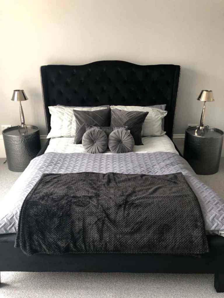 King size black velvet bed with large studded headboard
