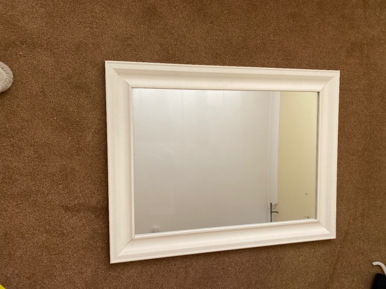 Mirror in a white wooden frame. 