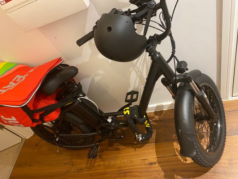 Black Electric Bike with Helmet and Delivery Bag
