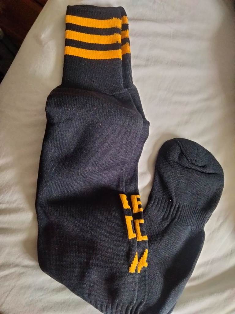 Brand new pair of black sports socks EDA with bright orange stripes