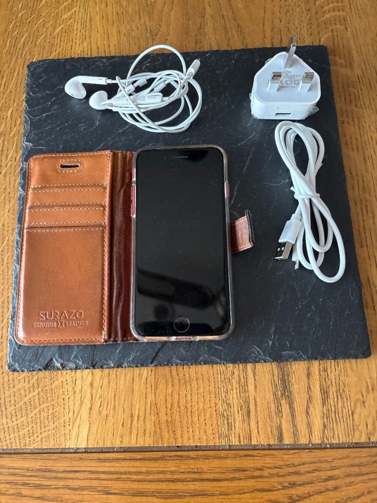 Apple iPhone with Case, Charger, and Headphones