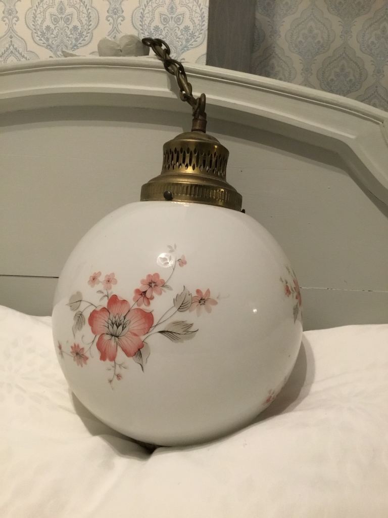 Milk coloured glass ceiling lampshade in the shape of a globe with floral design. 1970s.