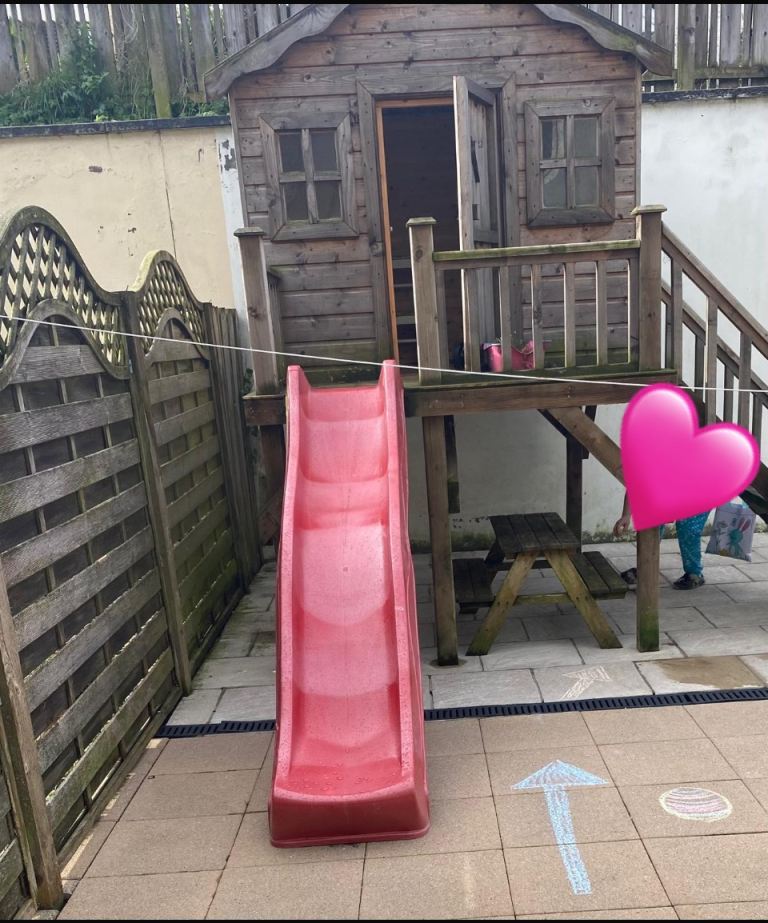 Wooden stilted playhouse with slide