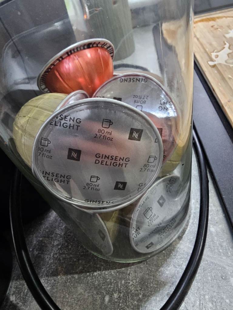 Nespresso veturo pod coffee maker machine in white with Nespresso cups/saucers, storage jar and pods