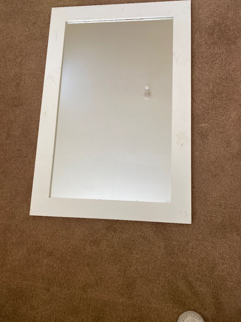 Mirror in a white wooden frame. 
