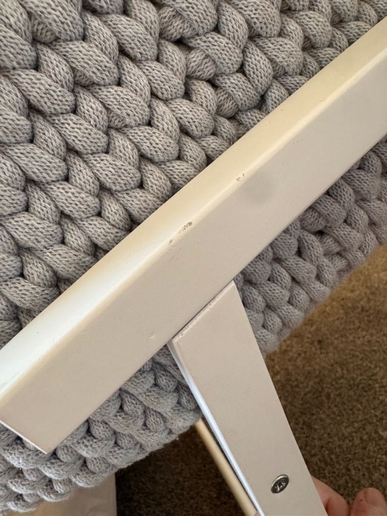 Light grey crochet crib with white wooden stand 