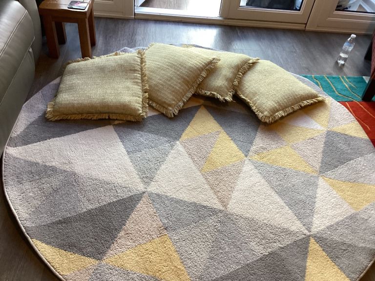 Dunelm circular rug yellow/grey/beige, 180cm diameter., and four co-ordinating cushions.