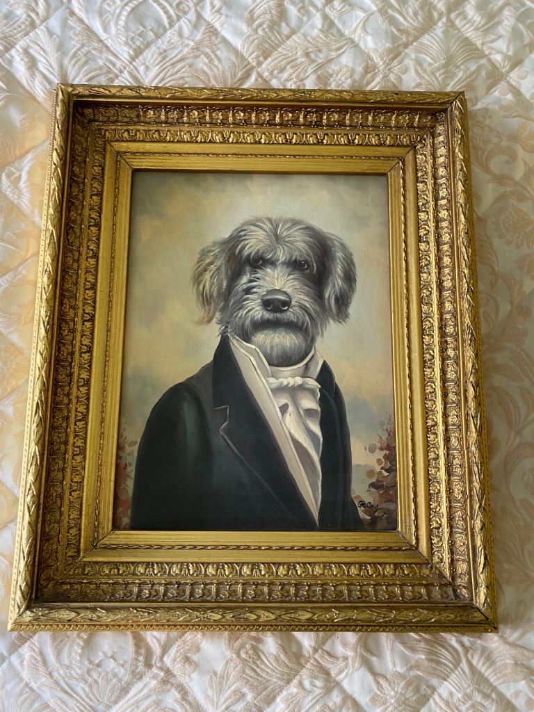 A pair of gilt framed dogs in human attire