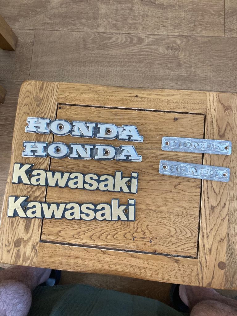 Vintage Honda and Kawasaki petrol tank badges.