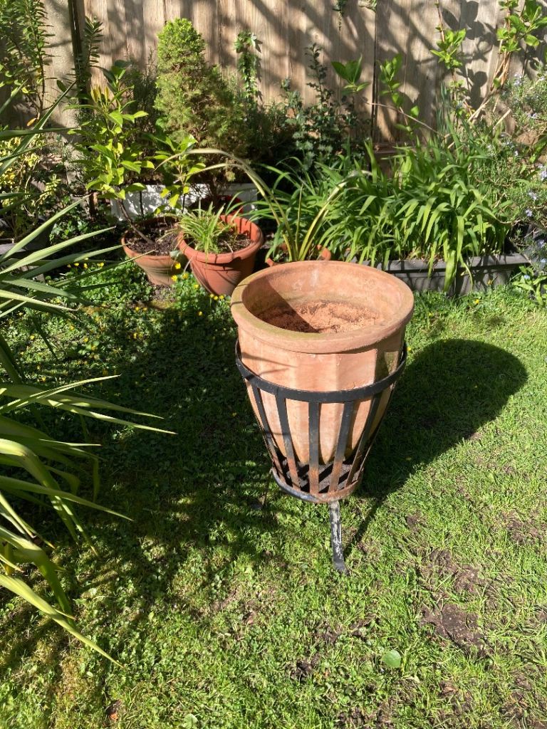 Large terracotta plant pot with metal basket stand