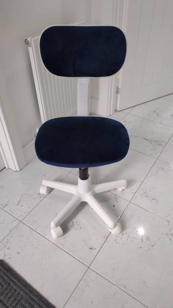 Comfortable kids chair with a navy blue velvet seat and backrest on a white sturdy base with wheels