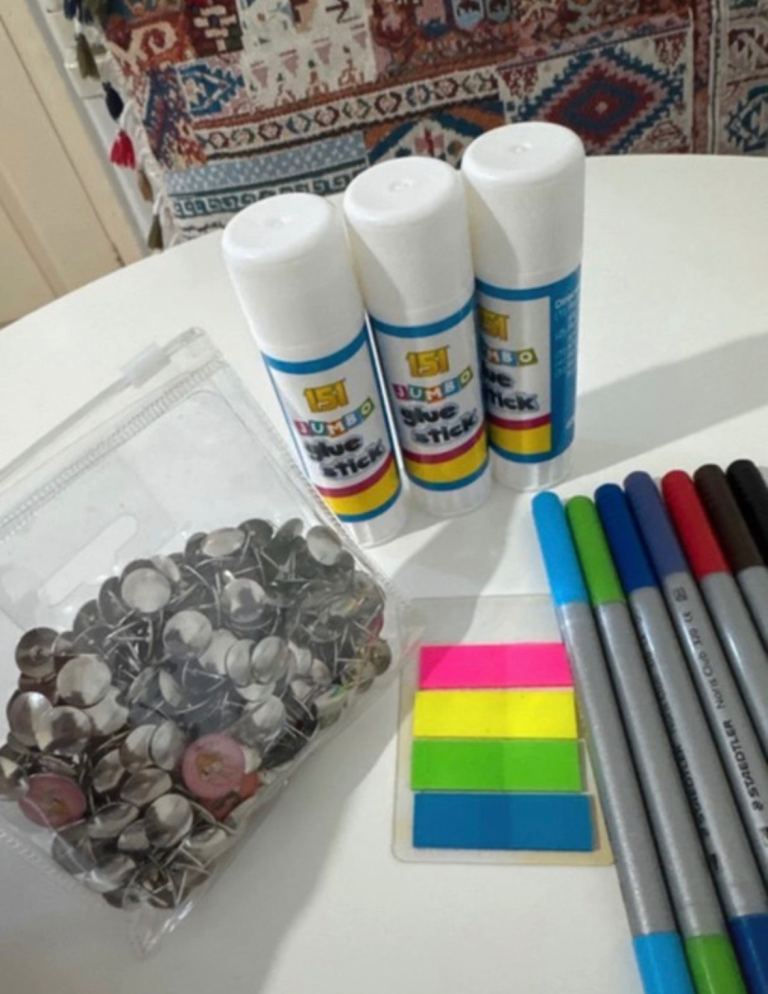 Assorted Stationery different pens, sketches, Glue sticks, pins, pencils, black ink cartridges.